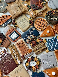 Decorated autumn harvest cookies with pumpkin and leaf designs in warm fall colors.
