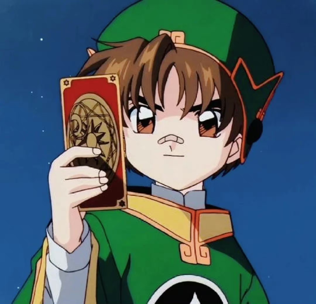 Anime boy Syaoran Li in green robes holding a red and gold Clow Card against a dark blue sky