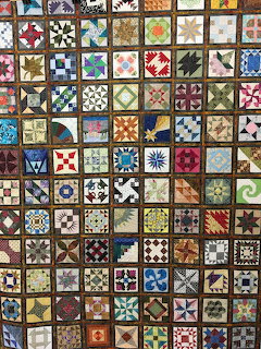 Colorful patchwork quilt with diverse geometric block patterns in a grid layout