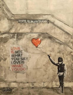 Graffiti mural of a child reaching toward a red heart balloon on a weathered wall