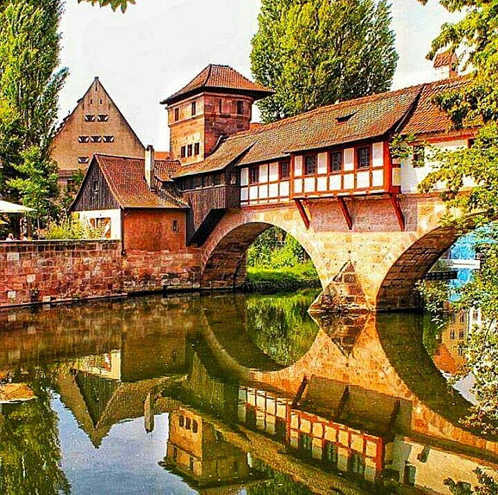 Historic Nuremberg bridge and half-timbered buildings reflected in river