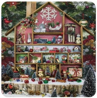 Miniature Christmas dollhouse with festive decorations, ornaments, and tiny trees in a winter display