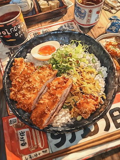 Teriyaki salmon rice bowl with egg, corn, and green onions on a wooden table with side dishes
