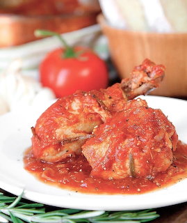 Chicken cacciatore with tomato sauce on white plate
