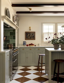 Kitchen with green cabinets, exposed beams, checkered floor, and window with natural light