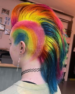 Person with rainbow mohawk hairstyle in gradient colors from red to violet