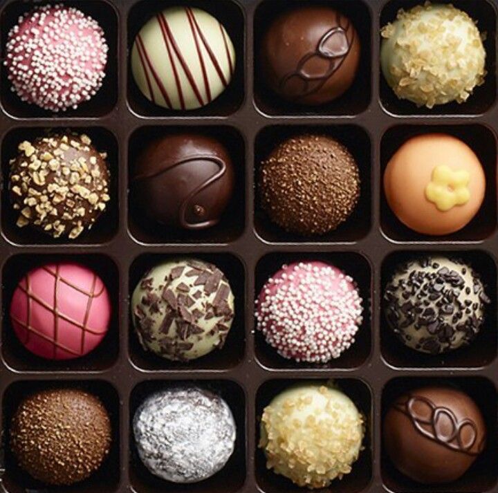 Assorted chocolate truffles and bonbons in a gift box with varied toppings and designs
