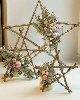 Wooden star decorations with pine branches and ornaments on white table