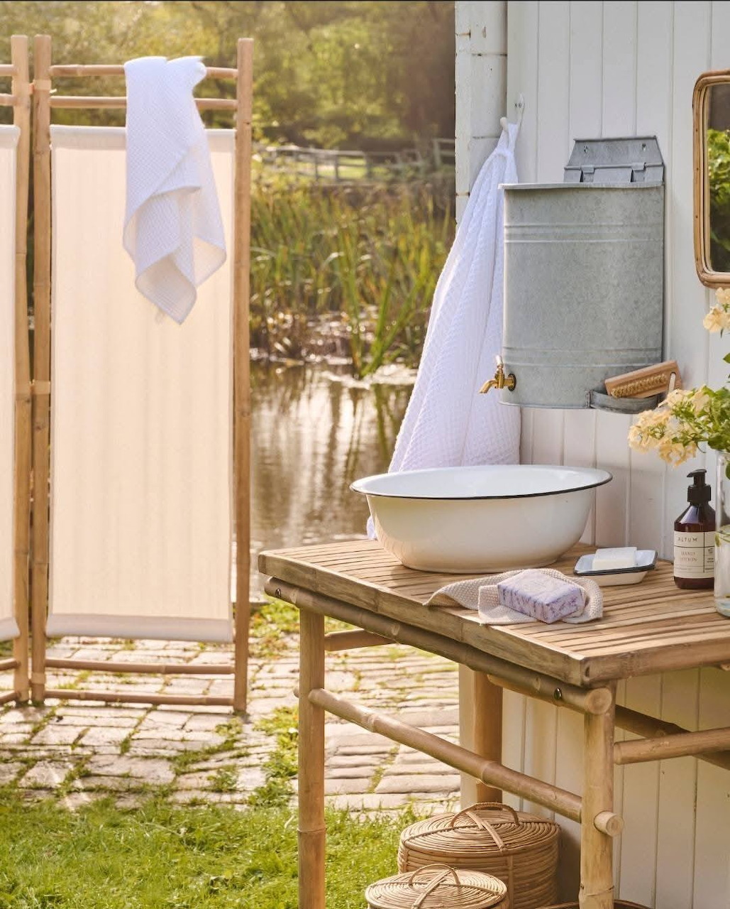Vintage washing station with enamel basin, pitcher, and washboard outdoors in sunlit garden