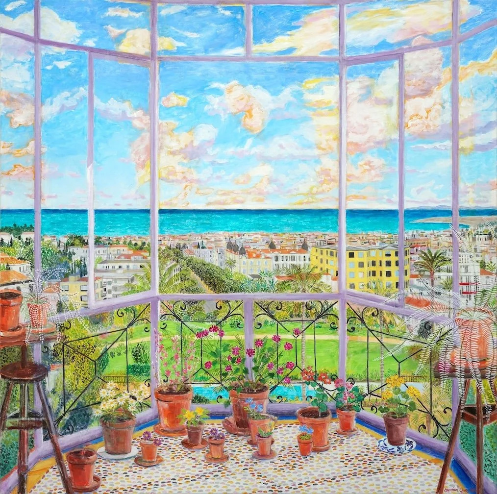 Bright studio balcony with potted flowers, easel, and turquoise ocean view through large windows
