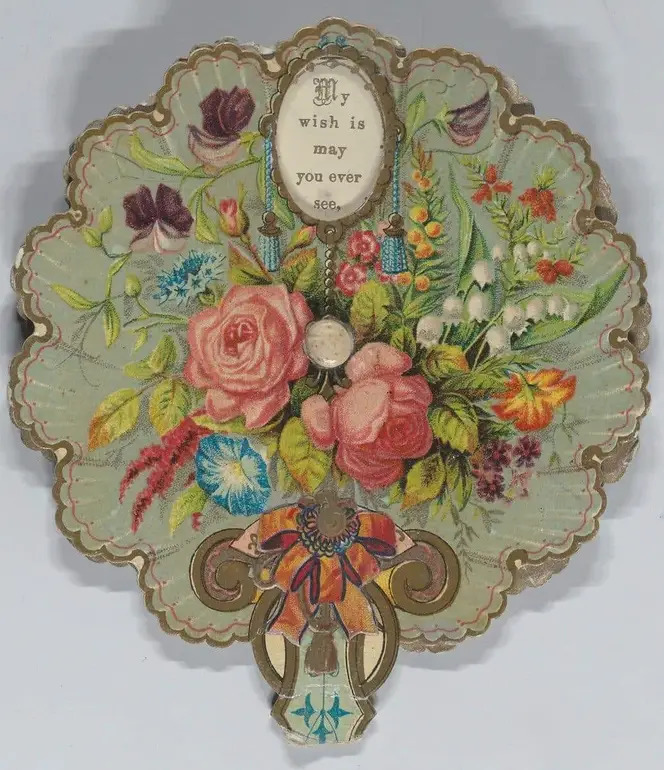 Ornate vintage hand fan with floral design, gold scalloped edges, and decorative handle on gray background