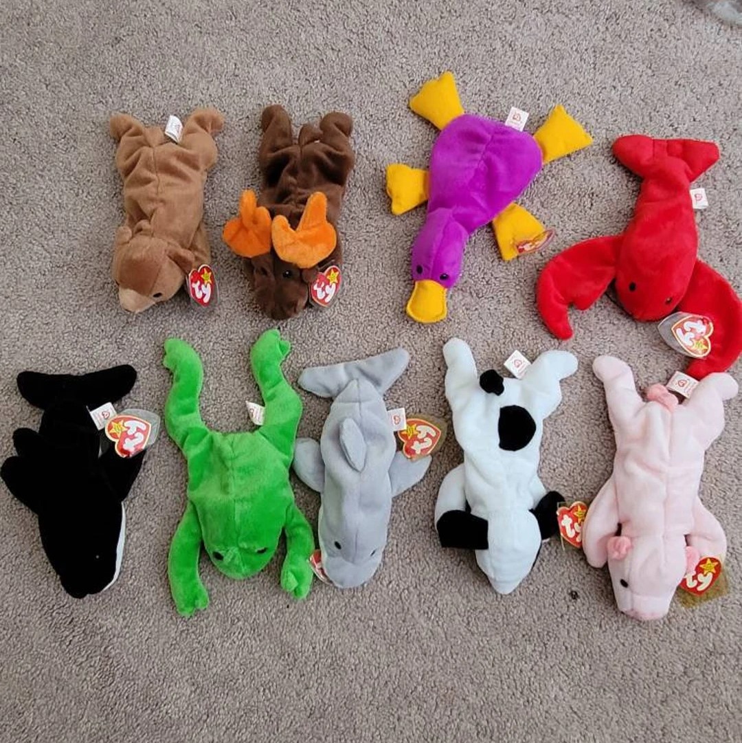 Nine original Beanie Babies plush toys displayed on gray carpet with red heart tags
