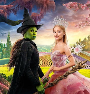 Green witch in black hat and pink-gowned good witch with wand in fantasy landscape