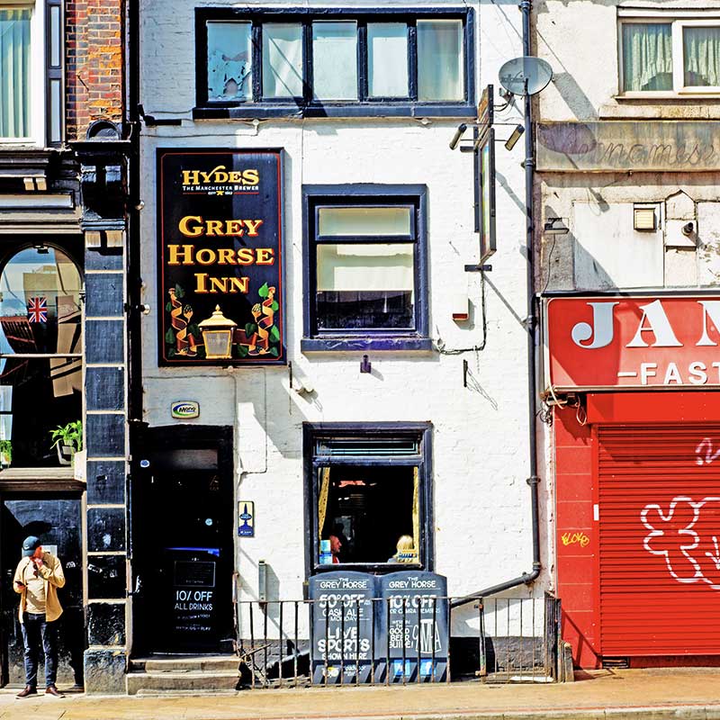 Grey Horse Inn pub facade with Hydes brewery sign in Manchester, England