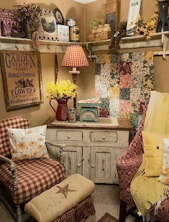 Vintage Americana kitchen corner with patchwork quilt, antique cabinet, gingham chair, and country decor