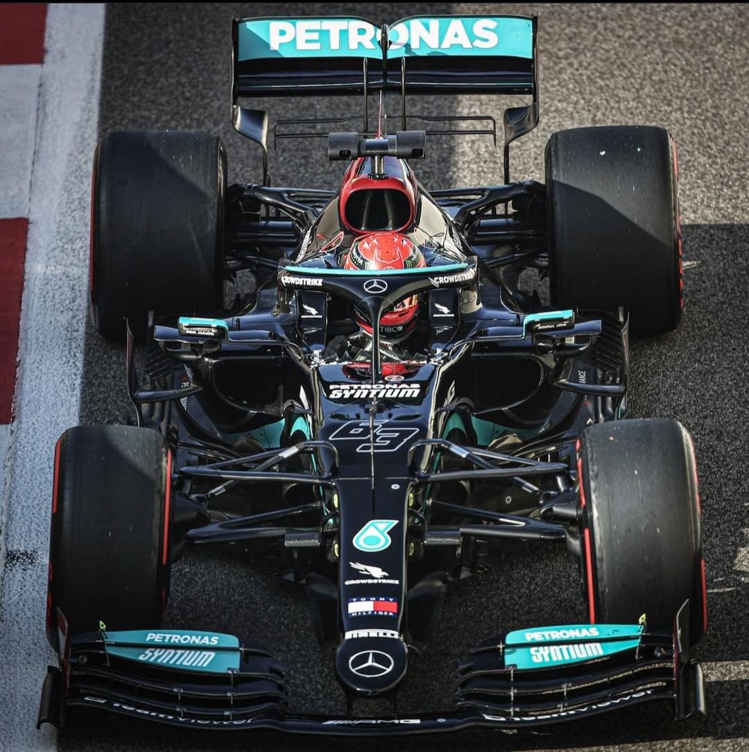 Overhead view of black Formula 1 race car with turquoise details on asphalt track