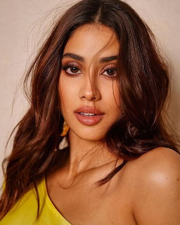 Close-up portrait of Janhvi Kapoor with wavy dark hair and a yellow top