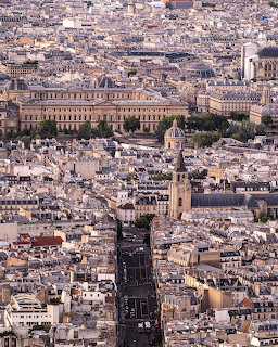 Aerial photograph of Paris showing densely packed historic buildings and rooftops with church spires