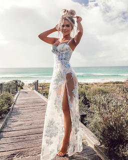 Woman in white lace dress on beach boardwalk with ocean view