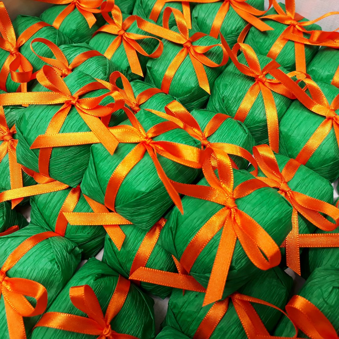 Multiple green gift boxes with orange and yellow striped ribbon bows