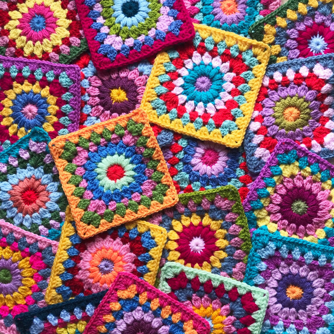 Colorful crocheted granny squares with concentric circular patterns in bright rainbow colors