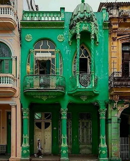 Vibrant green art nouveau building with ornate balconies and columns in Havana, Cuba