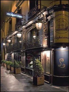 Night view of Restaurant Lapérouse in Paris with ornate black iron street lamps and warm lit facade