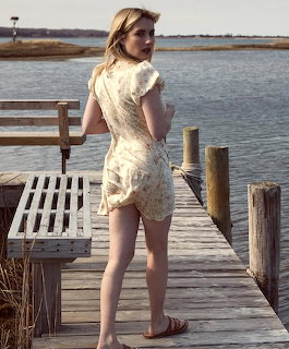 Woman in white lace dress on wooden dock by water