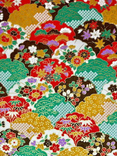 Colorful Japanese origami paper pattern with floral designs and layered cloud shapes