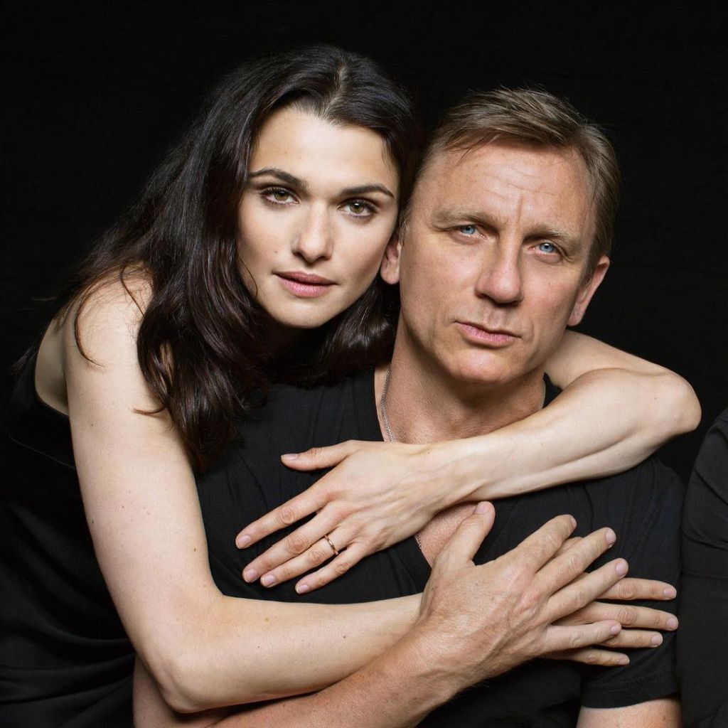 Rachel Weisz embracing Daniel Craig in a studio portrait against a black background