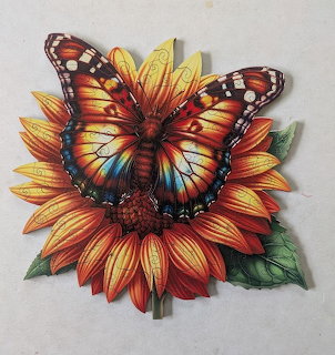 Colorful butterfly with patterned wings perched on a bright orange and yellow sunflower