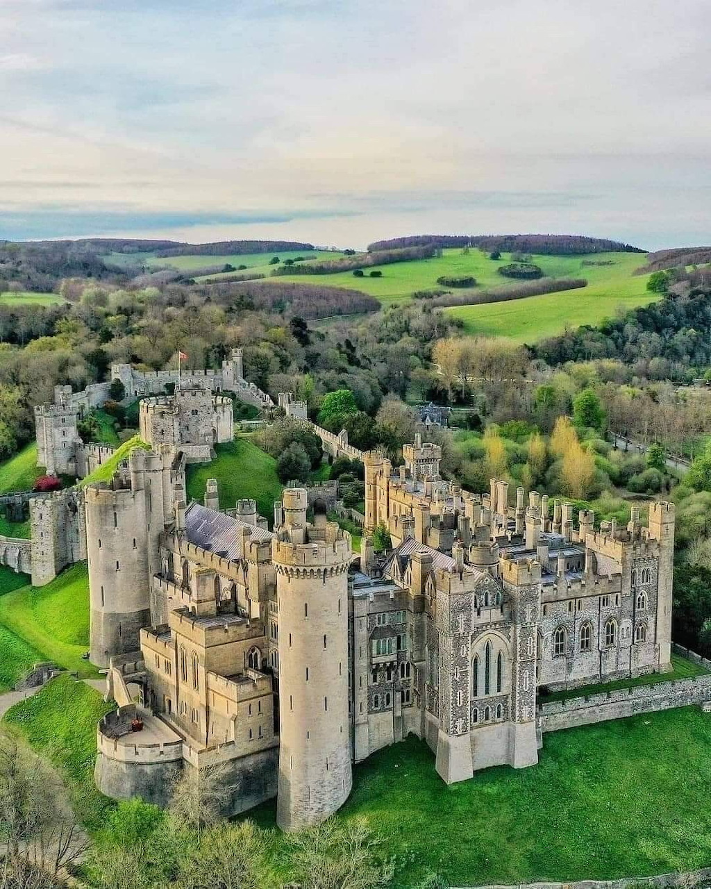 Aerial photograph of Arundel Castle with its towers and walls surrounded by green fields and trees