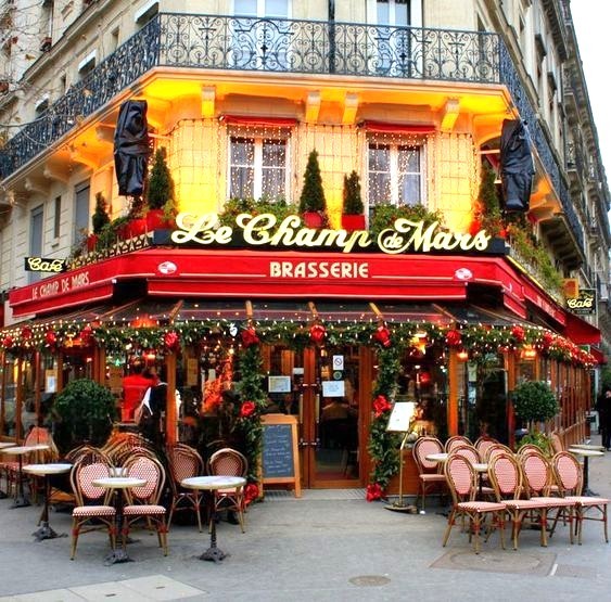 Decorated French brasserie corner with outdoor seating and holiday lights