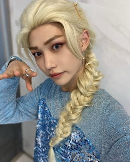 Person in Elsa cosplay with braided blonde hair and blue sparkly dress