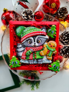 Christmas ornament with a cartoon owl in a red hat and scarf inside a red frame, with baubles and pinecones
