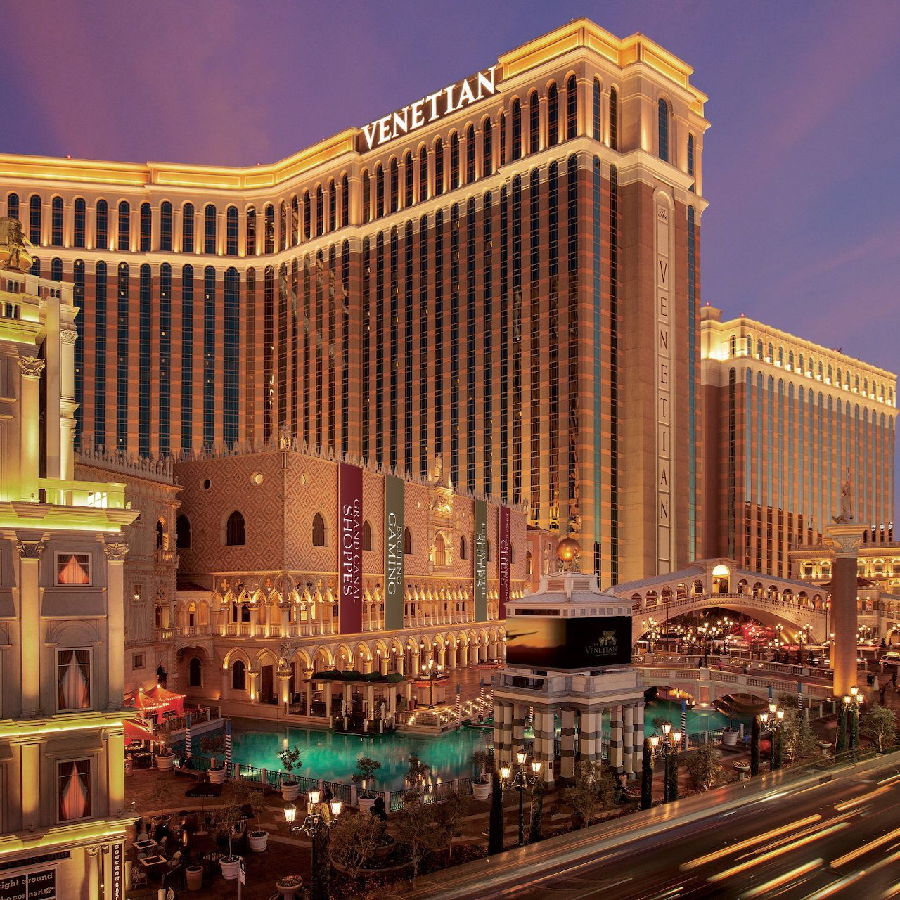 Night view of the Venetian hotel in Las Vegas with canal, bridges, and light trails