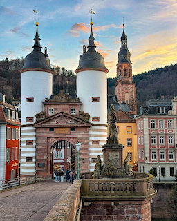 Historic bridge gate with twin white towers in Heidelberg at sunset
