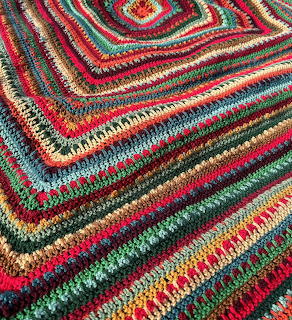 Colorful handmade crochet blanket with concentric square pattern in multiple vibrant colors