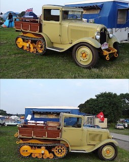 Beige vintage half-track pickup truck with wooden side panels and blue canopy parked outdoors