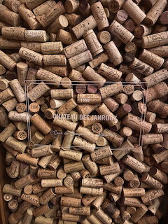 Hundreds of wine corks piled together with a clear sign reading Château des Janroux