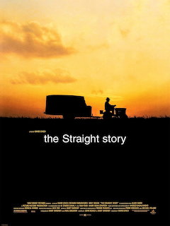 Silhouette of person on lawn mower with trailer at sunset