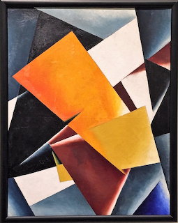 Abstract geometric painting by Lioubov Popova with layered angular shapes in orange, white, black, blue, and red