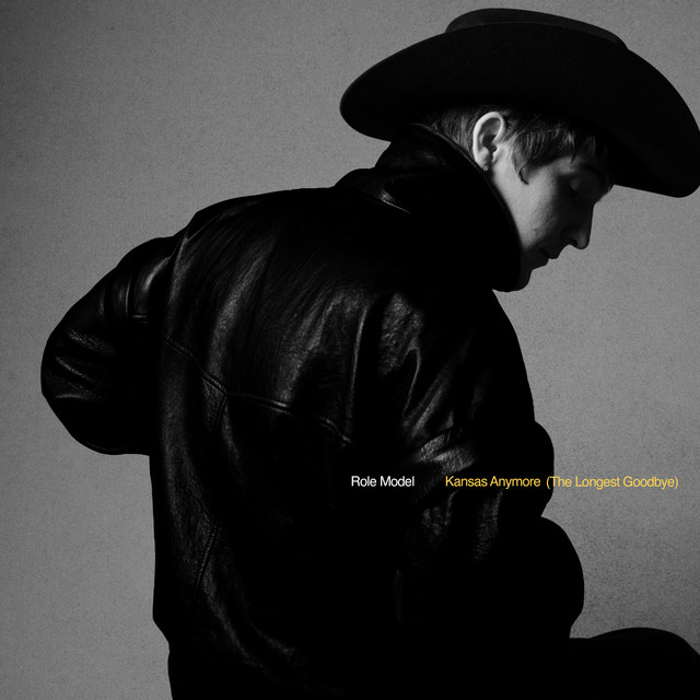 Black-and-white side profile of a man in a cowboy hat and leather jacket