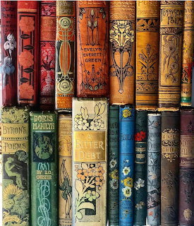 Rows of vintage book spines with ornate gold embossing and decorative patterns on aged leather covers