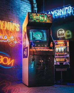 Retro arcade cabinet and slot machine surrounded by colorful neon signs in a dark gaming room