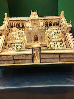 Intricate ivory miniature model of an Indian palace with elephants and arched courtyard on green surface