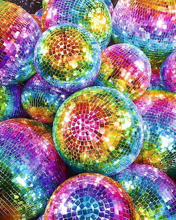 Cluster of reflective disco ball ornaments in rainbow colors including pink, purple, blue, green, and gold