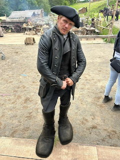 Actor in historical costume with tricorn hat and tall leather boots on an outdoor film set