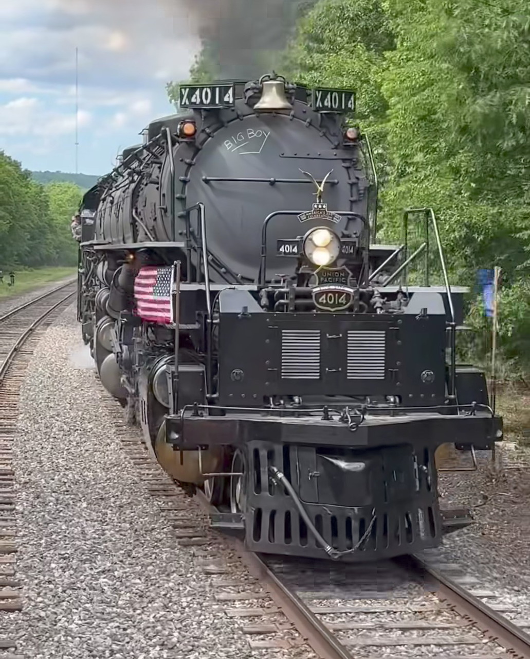 Union Pacific Big Boy steam locomotive 4014 on railroad tracks with black smoke and American flag
