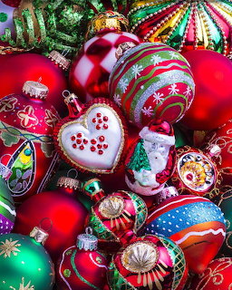Collection of colorful Christmas ornaments with red, green, and multicolored baubles and heart-shaped decorations